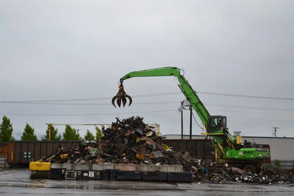 Material handler with a grapple in a scrap yard