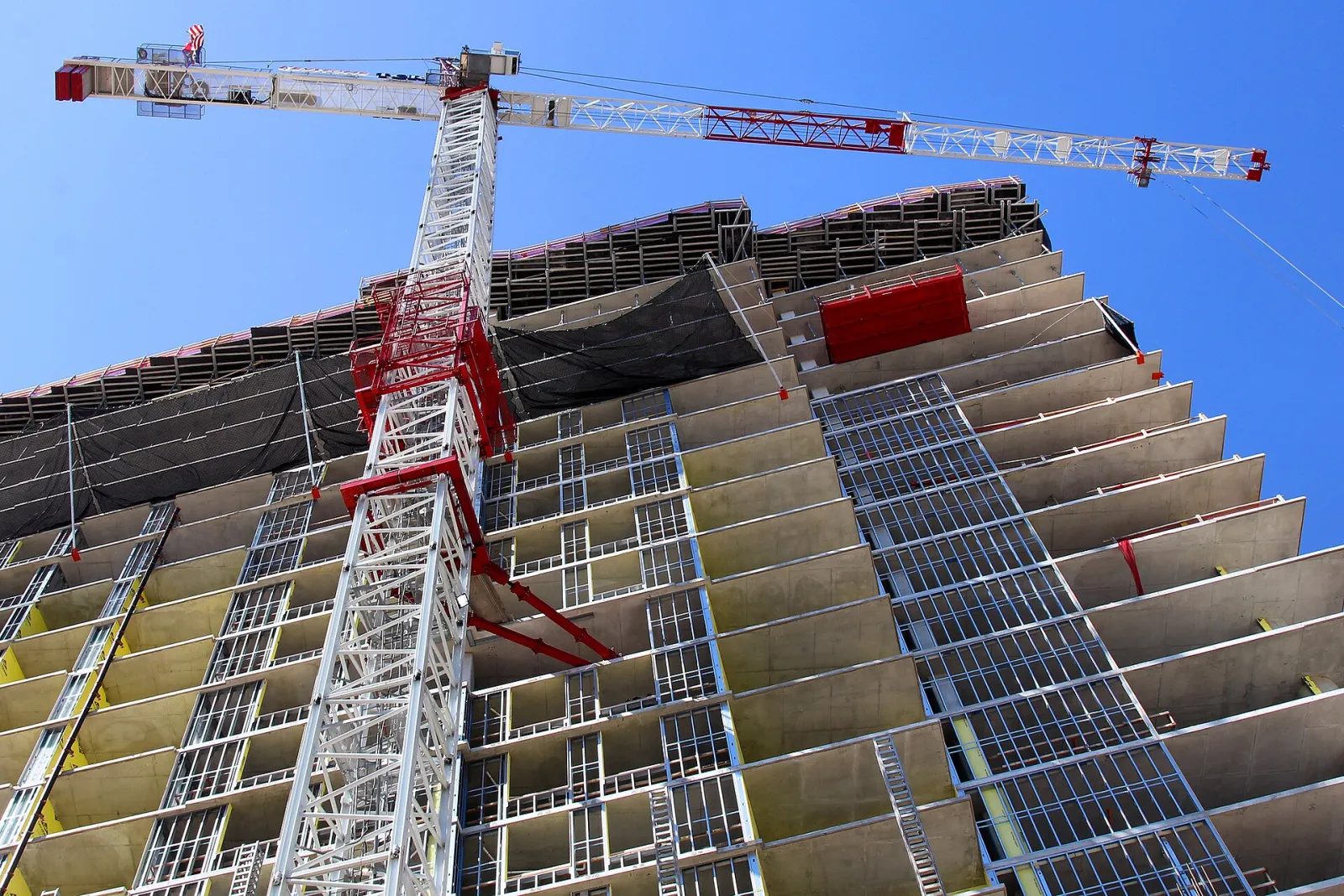 Tower crane beside a high-rise building under construction