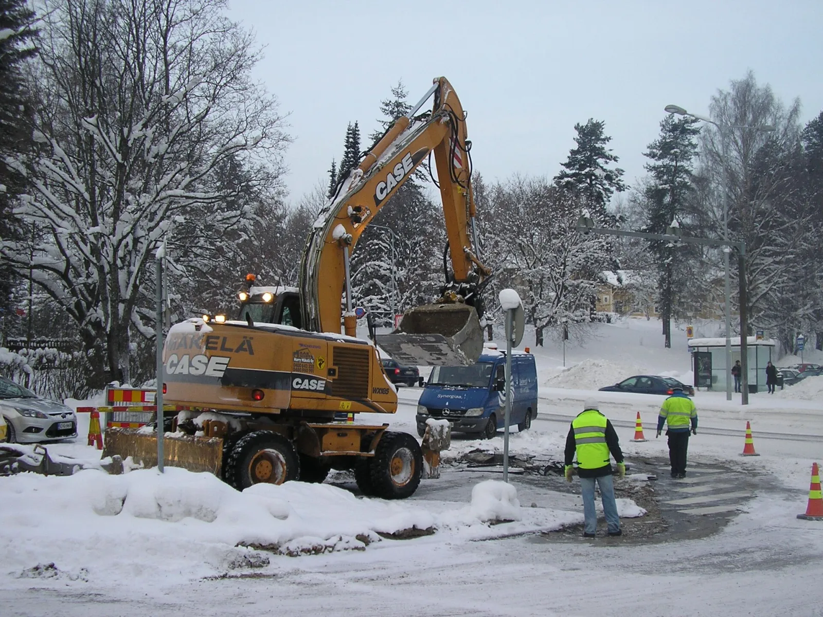 Wheeled excavator working on a street in winter