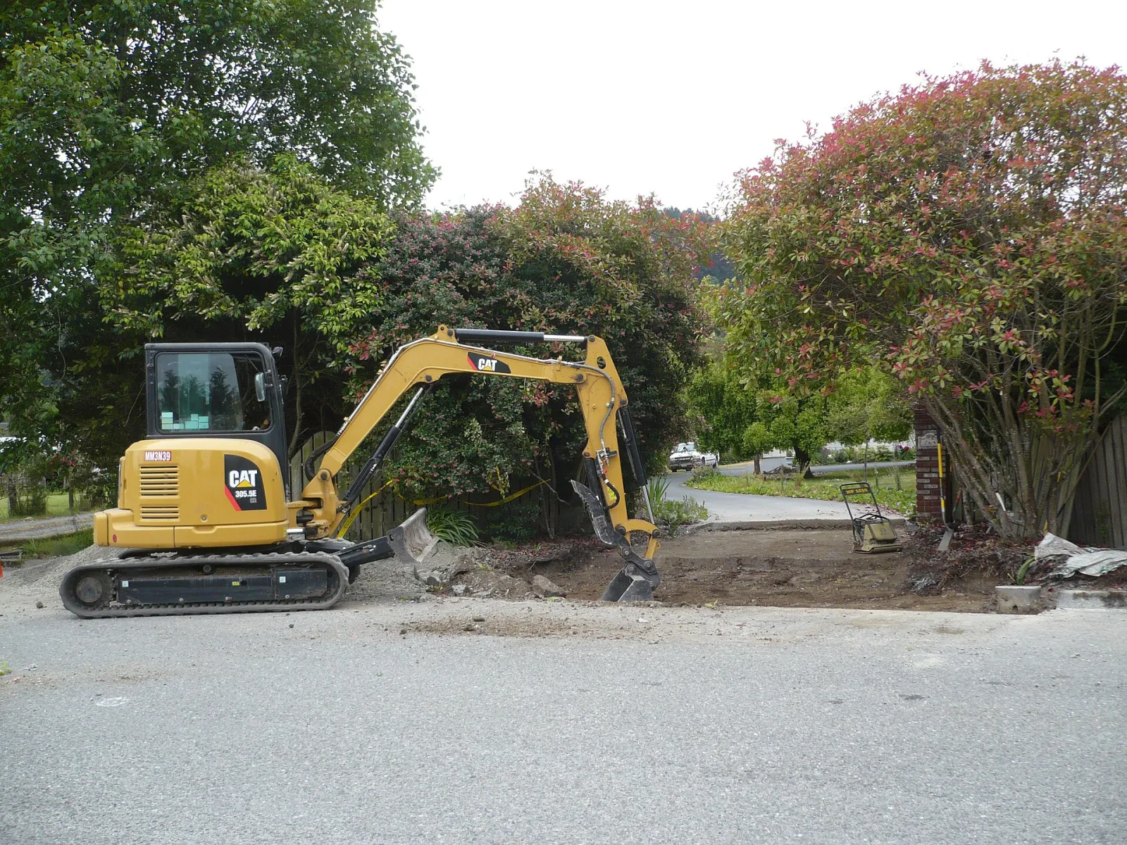 Caterpillar mini excavator digging a driveway