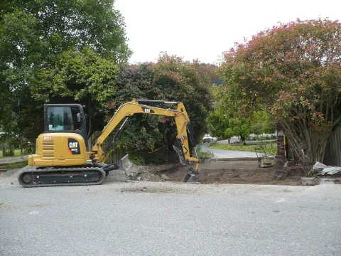 Caterpillar mini excavator digging a driveway