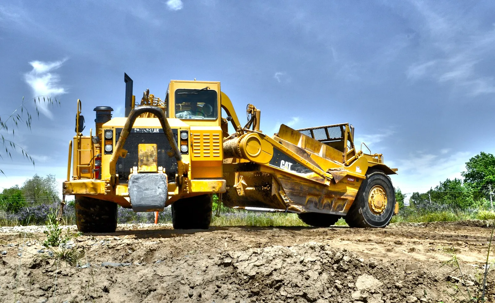 Wheel tractor-scraper working on a levee