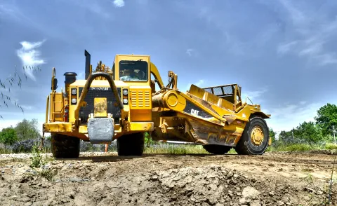 Wheel tractor-scraper working on a levee