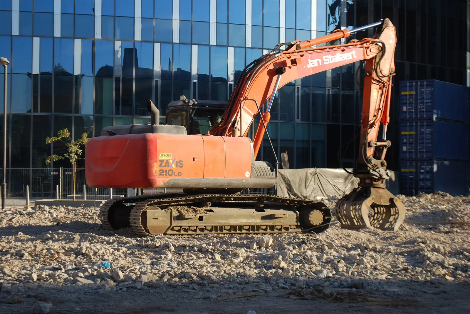 Orange Hitachi Zaxis crawler excavator on an urban construction site
