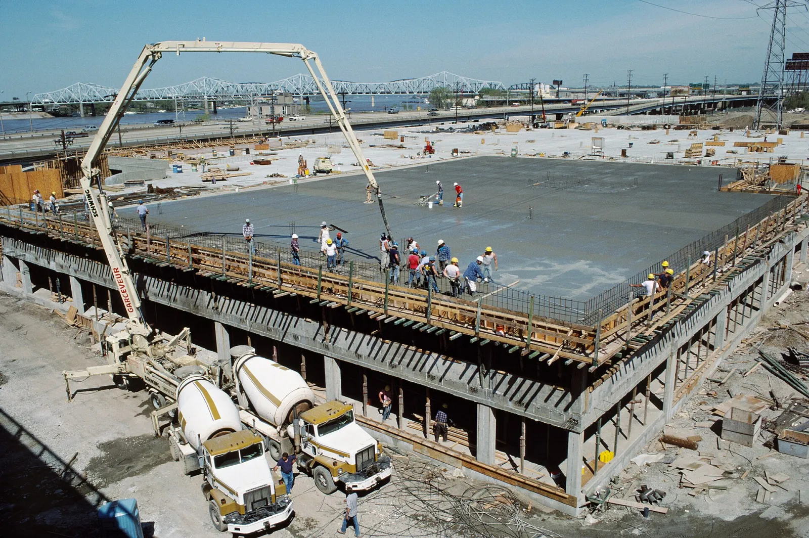 Concrete boom pump placing concrete on a parking garage deck
