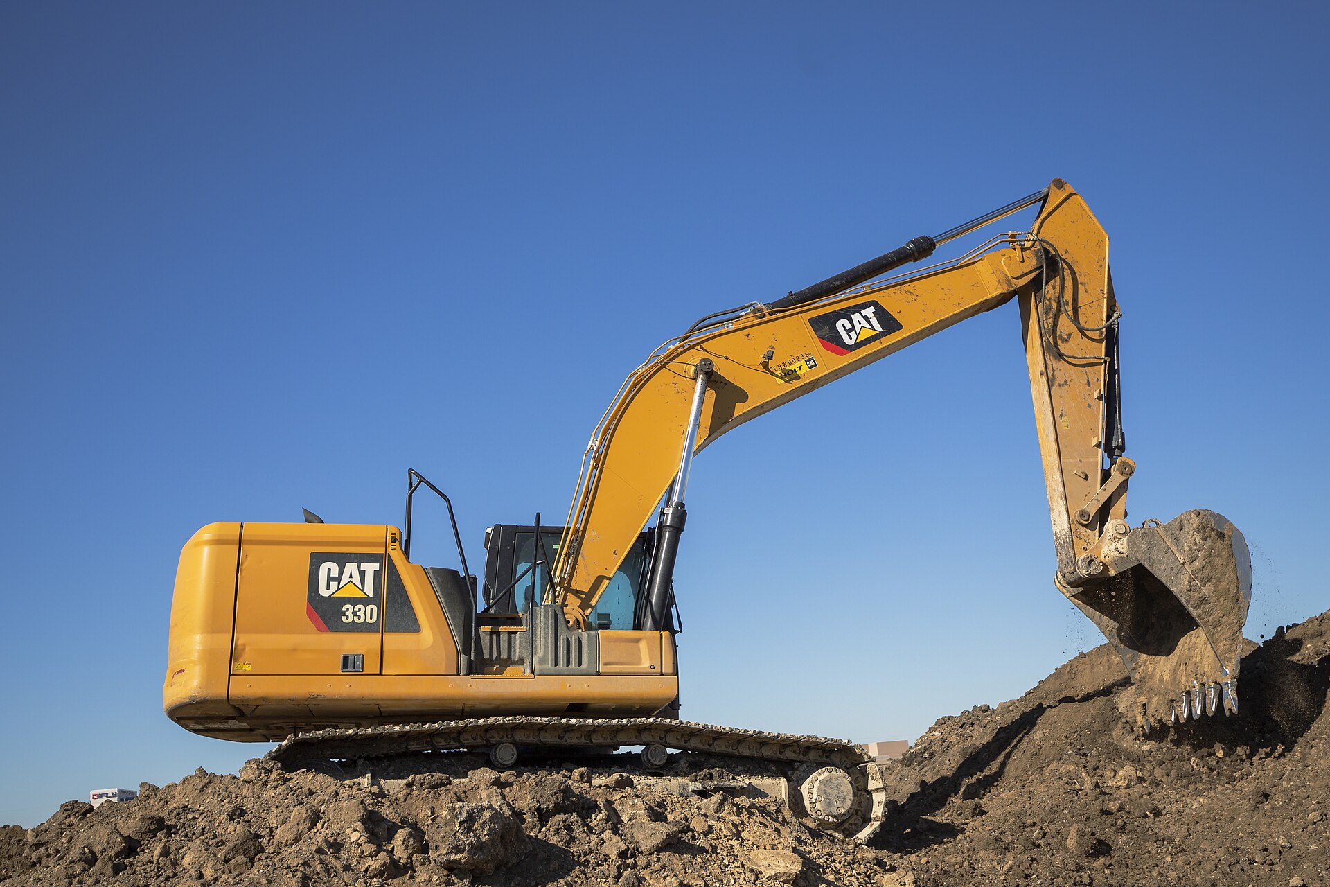 Caterpillar 330 excavator on a pile of dirt